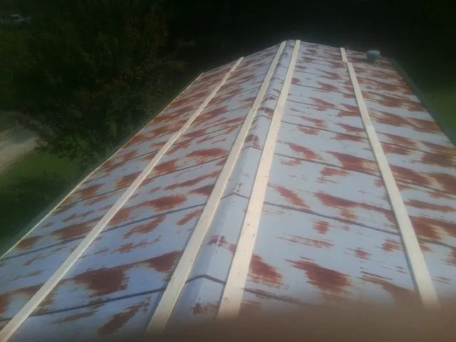 Rusted metal roof panels with new wood purlins before replacement — Storm Damage Roof Repair in Corona Del Mar by Roofing Brothers